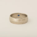 Subtle Knife's Edge Platinum Distressed Finish with Interior Blue Sapphire Flush Set Wedding Band
